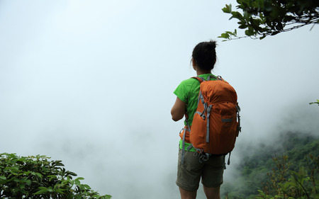 young woman backpacker in spring forest mountain peakの写真素材