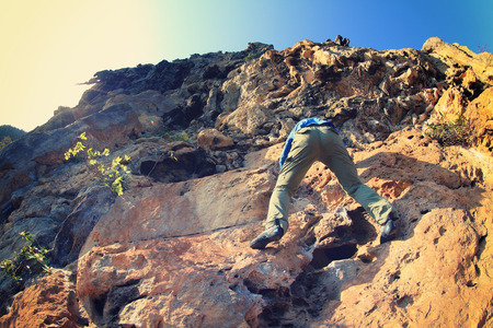 young woman rock climber climbing at mountain cliffの写真素材