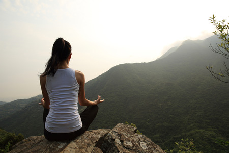 young fitness yoga woman at mountain peakの写真素材