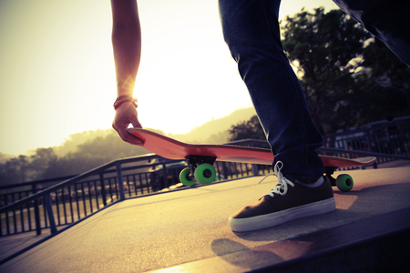 young woman skateboarder skateboarding at skateparkの写真素材