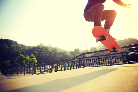 young woman skateboarder skateboarding at skateparkの写真素材