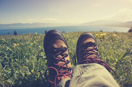 hiker sitting on a grass mountain top with first person perspective viewの写真素材