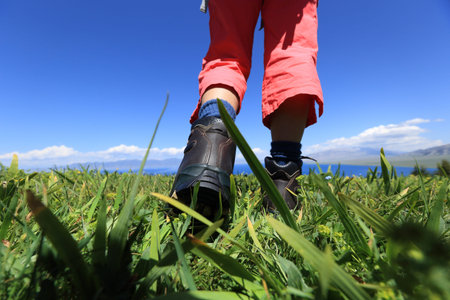 hiker legs on a grass mountain top with first person perspective view