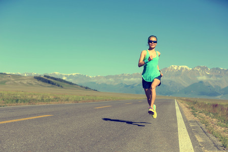 healthy lifestyle young fitness woman runner running on roadの写真素材