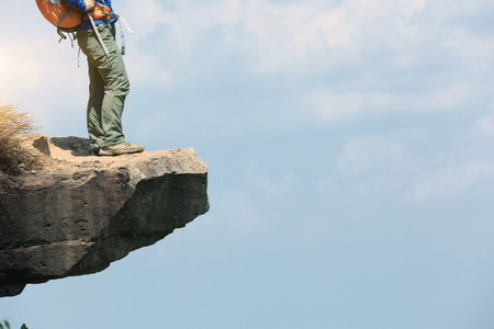young woman backpacker hiking on seaside mountain peak
