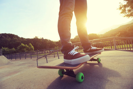 young skateboarder legs skateboarding at skate park