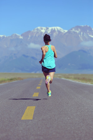 healthy lifestyle young fitness woman runner running on roadの写真素材