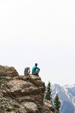 successful woman backpacker hiking  on mountain peak cliffの写真素材