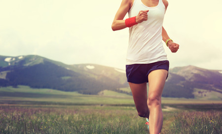 healthy lifestyle young fitness woman runner running on grasslandの写真素材