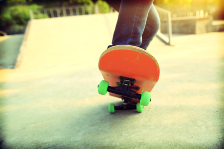 young skateboarder legs skateboarding at skateparkの写真素材