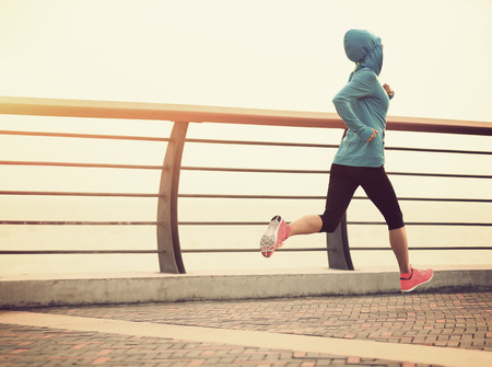 young fitness woman running at seasideの写真素材