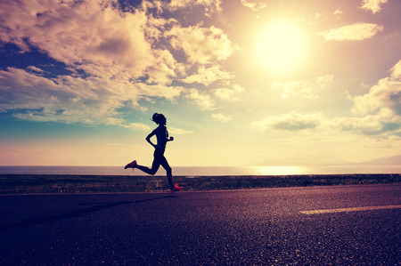 healthy lifestyle young fitness woman runner running on roadの写真素材