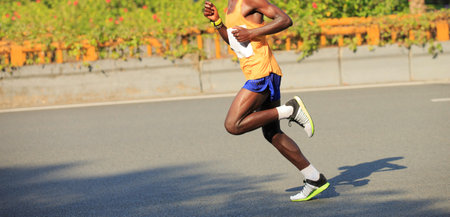 fitness male marathon runner running on city road