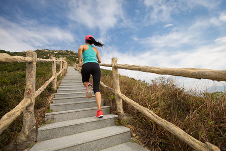 young fitness woman running on mountain stairs