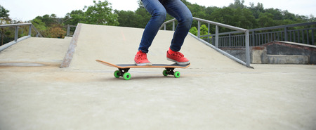 skateboarder legs doing a ollie trick at skateparkの写真素材