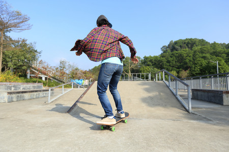 young skateboarder riding skateboard at skateparkの写真素材
