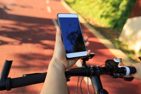 closeup of hands use gps navigator on cellphone while bikingの写真素材