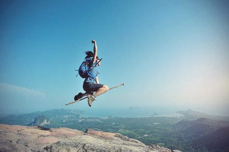 jumping on rocky mountain peak, freedom, risk, challenge, success conceptの写真素材