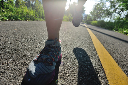 Young fitness woman running on morning tropical forest trail