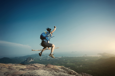 jumping on rocky mountain peak, freedom, risk, challenge, success conceptの写真素材