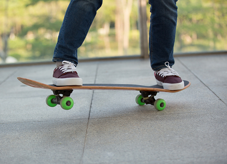closeup of skateboarder legs riding skateboard outdoorの写真素材