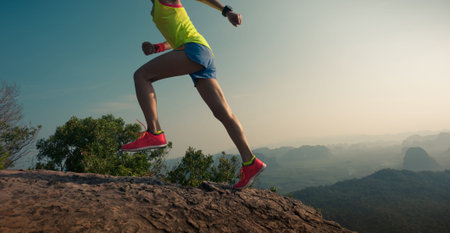 young woman trail runner running  up on mountain top