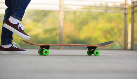 closeup of skateboarder legs riding skateboard outdoorの写真素材