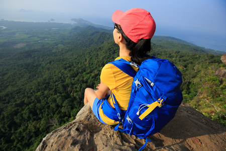 successful woman hiker enjoy the view hiking on mountain peakの写真素材