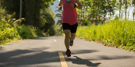healthy lifestyle woman running at morning tropical forest trail
