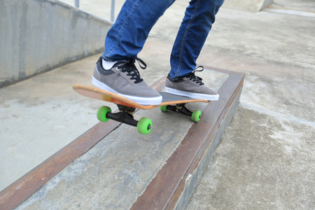 young woman skateboarder skateboarding at skateparkの写真素材