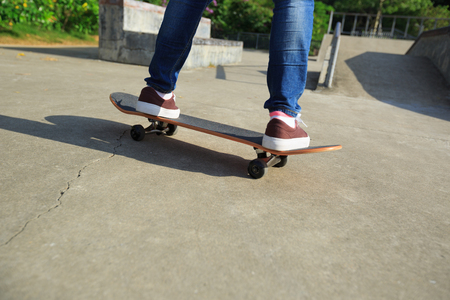 young skateboarder riding skateboard at skate parkの写真素材