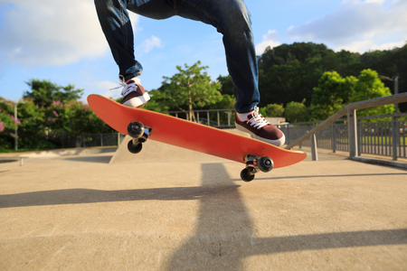 young skateboarder legs skateboarding at skateparkの写真素材