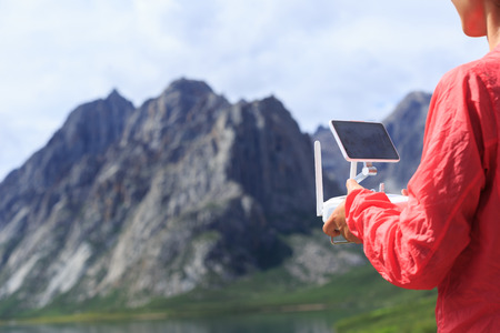 asian woman photographer flying drone outdoorsの写真素材
