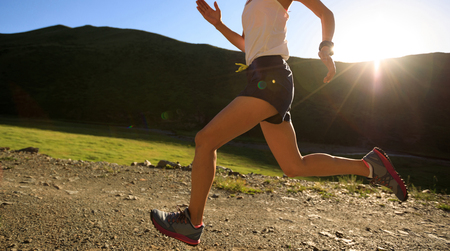 young fitness woman runner running on mountain trailの写真素材