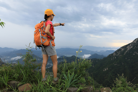 successful woman hiker enjoy the view on the top of mountainの写真素材