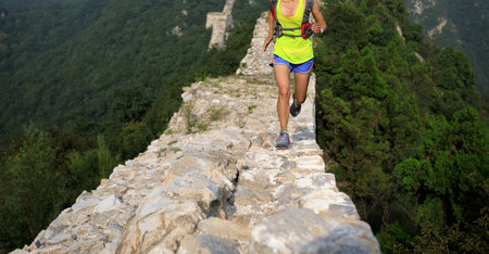 woman trail runner running on the great wall top of mountain
