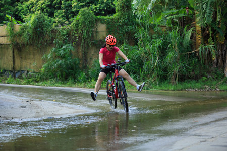 cyclist cycling mountain bike have run in water on trailの写真素材