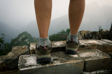 successful woman hiker legs on the top of great wallの写真素材