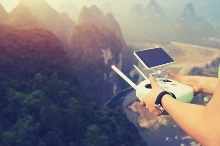 hands control the remote controller of drone outdoor