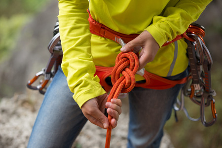 Ð¡limber wearing safety harness making a eight rope knot の写真素材