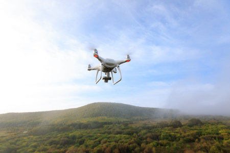 drone flying in the air over autumn forest
