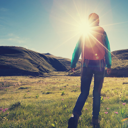 backpacking female hiking in sunrise mountainsの写真素材