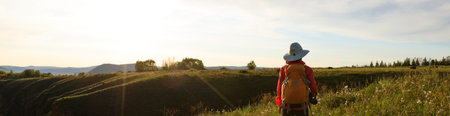 woman backpacker hiking on sunset mountain top