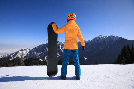 one snowboarder with snowboard on winter mountain topの写真素材