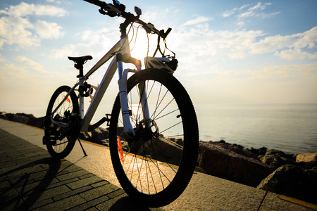 mountain bike with helmet on sunrise seasideの写真素材