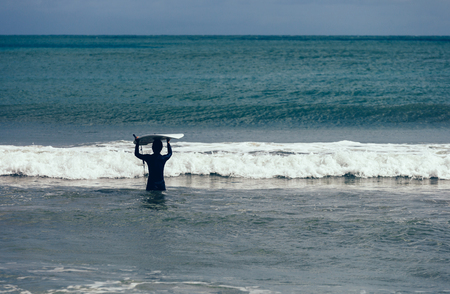  woman surfer with surfboard ready for surfingの写真素材
