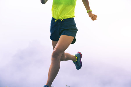 sporty fitness woman runner running on mountain top