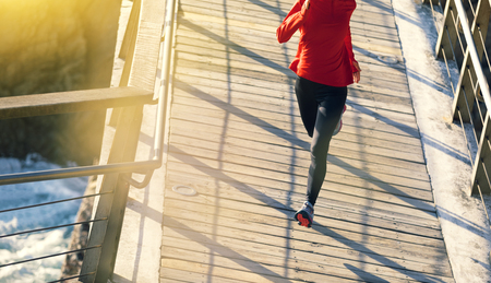 top view of sporty fitness woman runner running on seaside boardwalkの写真素材