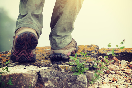 Successful hiker legs on the top of great wall in bad weatherの写真素材