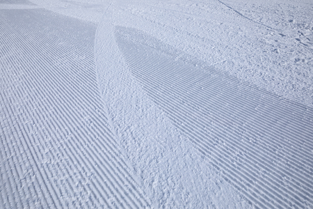 track lines on a ski slope left by a snowcatの写真素材